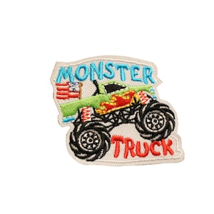 May include: Embroidered patch featuring a green monster truck with red and yellow flames, black tires, and the text "MONSTER TRUCK" in blue and red. Includes a small American flag. The patch has a white border.