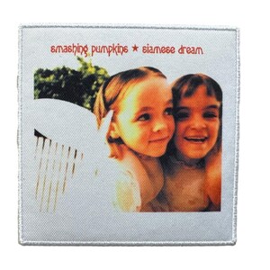 May include: Square patch featuring the album art from Smashing Pumpkins' "Siamese Dream." The image shows two young girls with a white wing-like shape on the left. The band name and album title are in red text at the top.