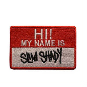 May include: Embroidered patch with a red top section and a white bottom section. The text "HI!! MY NAME IS" is in white, and "SLIM SHADY" is in black, all on a rectangular patch.