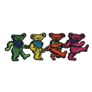 May include: Four embroidered dancing bears in green, yellow, orange, and pink. Each bear has a different colored collar and is holding hands with the others. The bears are on a white background.