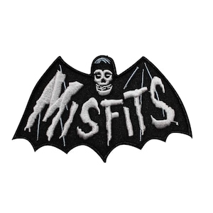 May include: Black and white embroidered patch in the shape of a bat. The word "MISFITS" is embroidered in white across the bat's wings. A skull is centered above the word. The patch is likely for clothing or accessories.