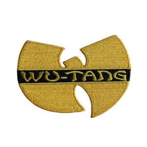 May include: A gold and black embroidered patch in the shape of the Wu-Tang Clan logo. The design features a stylized W shape with a horizontal black band across the center containing the gold embroidered text WU-TANG in a bold, sans-serif font.