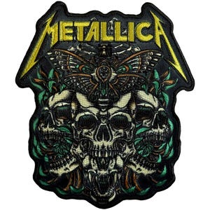 May include: Embroidered patch featuring the word "METALLICA" in yellow, above a design of three skulls, a moth, and green foliage. The patch is black with yellow lightning bolt accents.