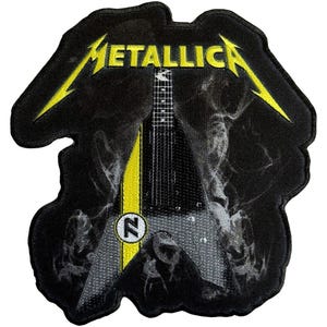 May include: Black patch featuring the band name "METALLICA" in yellow, with a stylized electric guitar design. The guitar has a yellow stripe down the center and a circular emblem with the letter "N".
