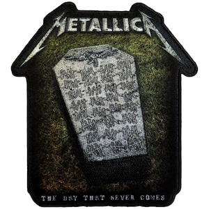 May include: A black patch with the band name "METALLICA" in silver, above a tombstone design. The tombstone is gray with etched lines, set against a green and brown background. The text "THE DAY THAT NEVER COMES" is at the bottom.