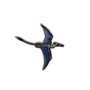 May include: Embroidered patch featuring a blue Pterodactyl in flight. The patch has a detailed design with a black outline and silver accents. This patch is suitable for jackets, bags, or other fabric items.