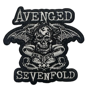 May include: Black and white embroidered patch featuring the words "AVENGED SEVENFOLD" around a skull with bat wings. The patch has a black border and white stitching, creating a detailed and gothic design.