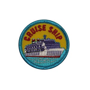 May include: Embroidered patch featuring a cruise ship design. The patch is circular, with a yellow background and a blue border. The words "CRUISE SHIP" are embroidered in red. The ship is white and purple, with red smokestacks, and blue water.