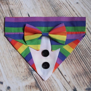 May include: A rainbow striped dog bandana with a white tuxedo bow tie and two black buttons.