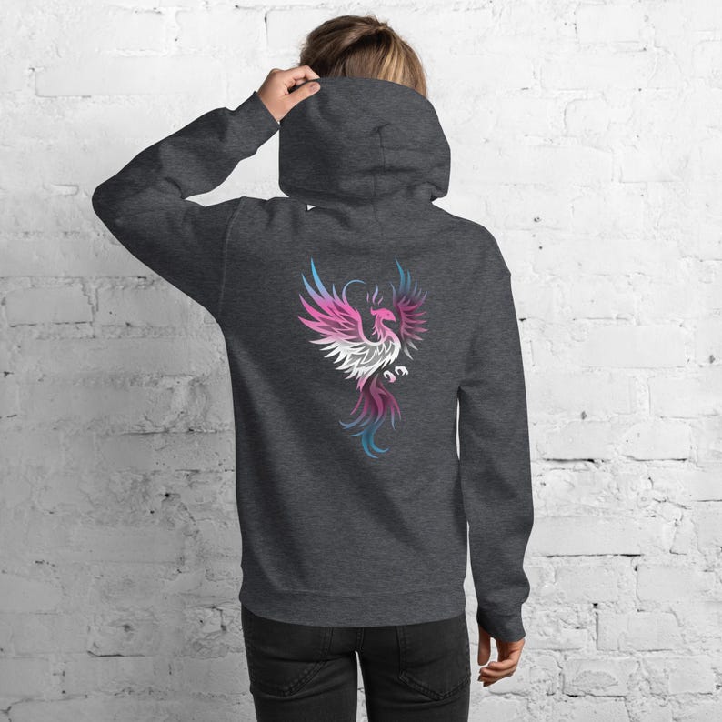 May include: Dark gray hoodie with a colorful phoenix design on the back. The phoenix is depicted in shades of pink, white, blue, and purple. The hoodie has a hood and long sleeves.