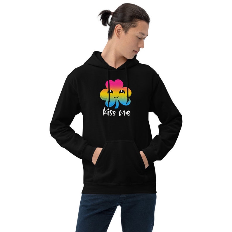 Pu&ograve; includere: Felpa con cappuccio nera con un trifoglio arcobaleno e il testo "kiss me" in bianco.