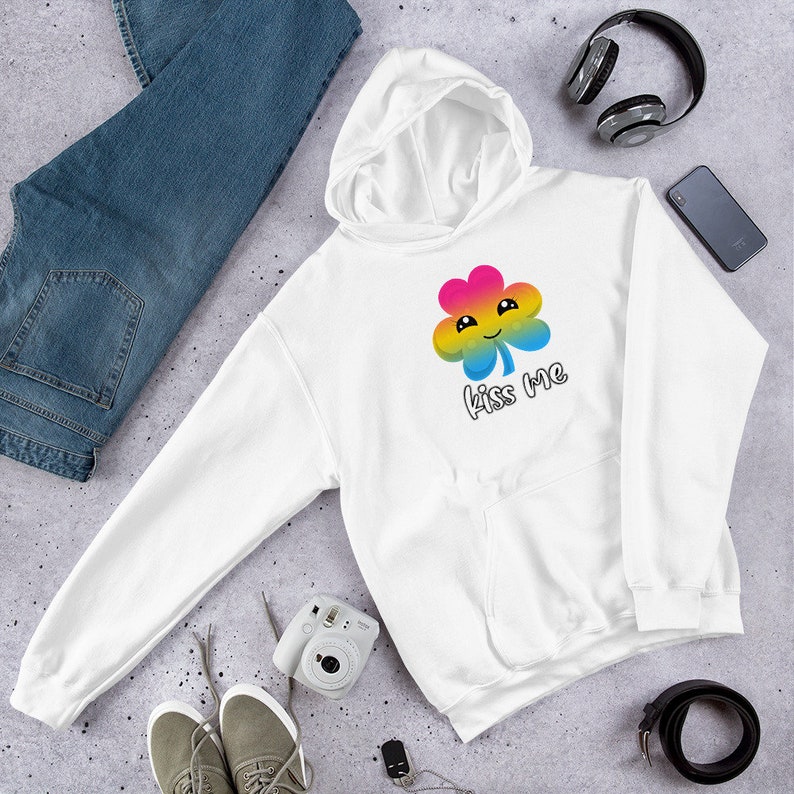 Pu&ograve; includere: Felpa con cappuccio bianca con un trifoglio arcobaleno e la scritta "Kiss Me" stampata sul davanti.