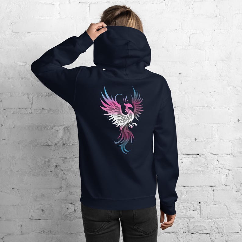 May include: Navy blue hoodie with a colorful phoenix design on the back. The phoenix is depicted in shades of pink, white, blue, and purple. The hoodie has a hood and a relaxed fit.