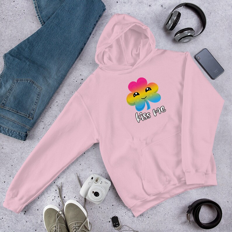 Pu&ograve; includere: Felpa rosa con un trifoglio arcobaleno e il testo "Kiss Me".