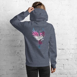 May include: A dark gray hoodie with a colorful phoenix design on the back. The phoenix is depicted in shades of pink, white, blue, and purple. The hoodie has a hood and a front pocket.