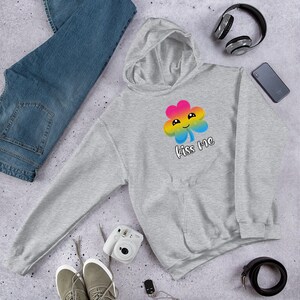 Pu&ograve; includere: Una felpa con cappuccio grigia con un design a trifoglio arcobaleno e il testo "Kiss Me".