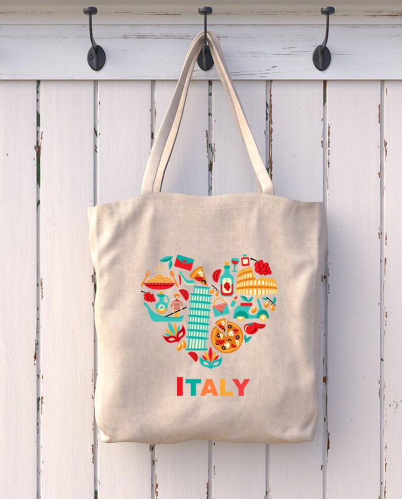 Op de afbeelding: Beige draagtas met een hartvormig ontwerp gevuld met Italiaanse iconen. Het ontwerp bevat pasta, pizza, de scheve toren van Pisa en het Colosseum. Het woord "ITALY" staat eronder in kleurrijke letters.