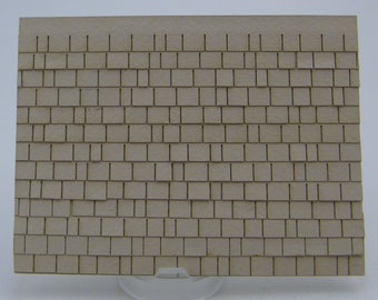 May include: A sheet of brown craft paper with a pattern of small squares, resembling a roof made of shingles.