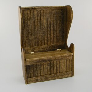 May include: A wooden storage bench with a high back and a hinged top. The bench is stained a dark brown color and has a rustic look.
