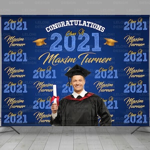 May include: A blue and gold graduation backdrop with the text "Congratulations Class of 2021 Maxim Turner" and a photo of a graduate in a cap and gown holding a diploma.