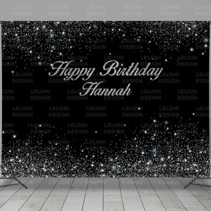 May include: Black backdrop with silver glitter and the text "Happy Birthday Hannah" in silver lettering.