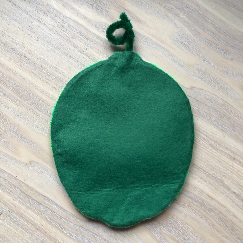 Puede incluir: Sand&iacute;a de fieltro verde con un tallo de fieltro verde. La sand&iacute;a es plana y redonda.