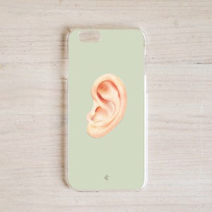 May include: A light green phone case with a drawing of a human ear on it.