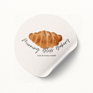 May include: A white sticker with a brown croissant illustration and the text "Morning Bliss Bakery" and "love in every crumb".