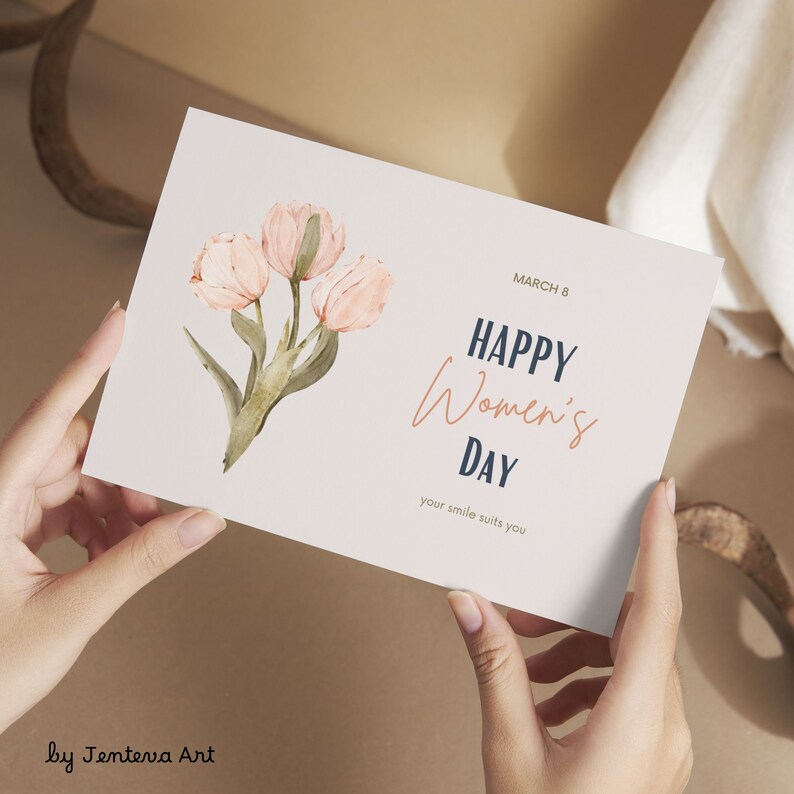 Puede incluir: Una tarjeta rosa y blanca con el texto "MARCH 8 HAPPY Women's DAY your smile suits you" y una ilustraci&oacute;n de acuarela de tulipanes rosas.