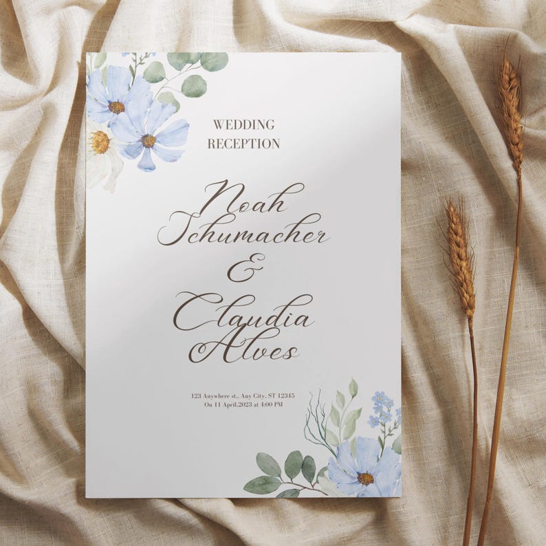 May include: A wedding reception sign with floral accents. The sign features the names "Noah Schumacher & Claudia Alves" in elegant script. The text "WEDDING RECEPTION" is at the top. The date and time are also included. The sign is decorated with blue flowers and green leaves.