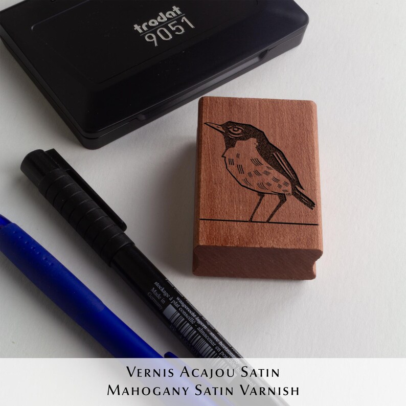 A rubber stamp with an illustration of a bird and the text EX LIBRIS CLEMENT SCARPI rests beside its stamped impression on a book page, making a parfait cadeau fait main for collectors of bijoux uniques or vintage treasures.