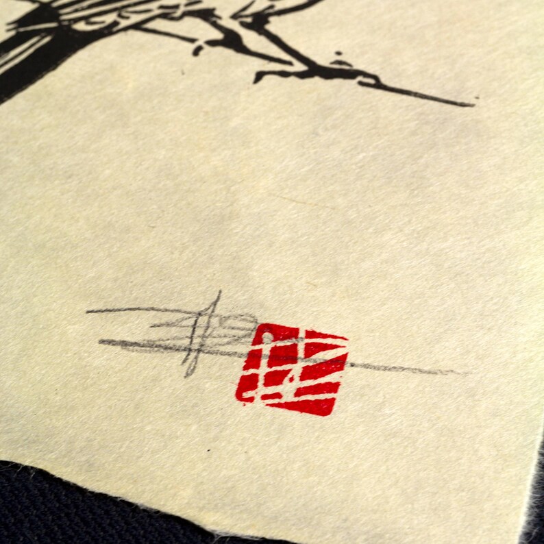 May include: Close-up of textured, off-white paper with a black ink drawing of a tree branch at the top. A red square stamp with white lines and a signature are at the bottom.
