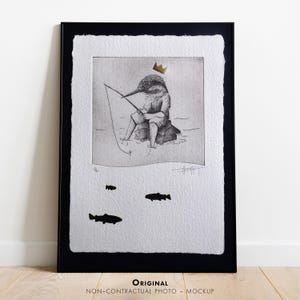 May include: Black framed art print featuring a whimsical illustration of a bird wearing a gold crown, fishing. The artwork is in black and white with three fish in the water. The print is on textured paper.