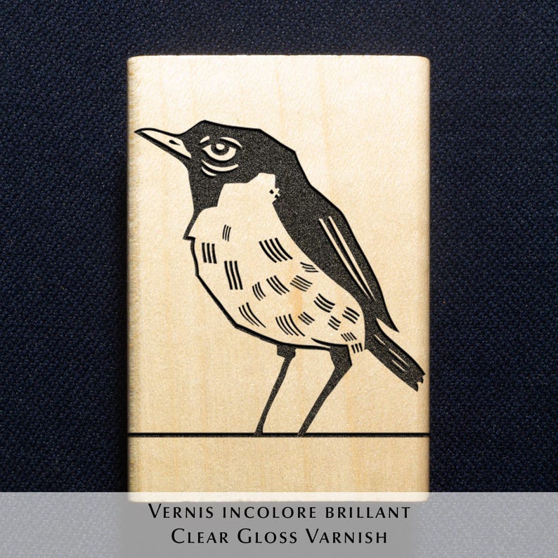 A rubber stamp with an illustration of a bird and the text EX LIBRIS CLEMENT SCARPI rests beside its stamped impression on a book page, making a parfait cadeau fait main for collectors of bijoux uniques or vintage treasures.