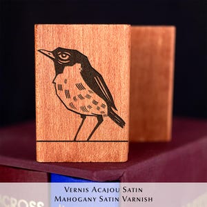 A rubber stamp with an illustration of a bird and the text EX LIBRIS CLEMENT SCARPI rests beside its stamped impression on a book page, making a parfait cadeau fait main for collectors of bijoux uniques or vintage treasures.