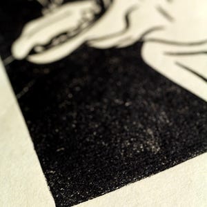 May include: Black and white print of a stylized image. The print is numbered 3/100.