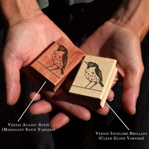 A rubber stamp with an illustration of a bird and the text EX LIBRIS CLEMENT SCARPI rests beside its stamped impression on a book page, making a parfait cadeau fait main for collectors of bijoux uniques or vintage treasures.