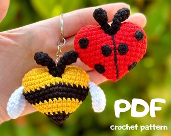 Puede incluir: Patrón de crochet PDF para una mariquita y una abeja, ambas en forma de corazón. La mariquita es roja con manchas negras y la abeja es amarilla con rayas negras. Ambas tienen alas blancas.