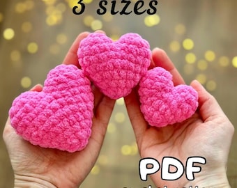 May include: Three pink crocheted hearts of different sizes, held in a person's hands. The image text reads "3 sizes" and "PDF crochet pattern".