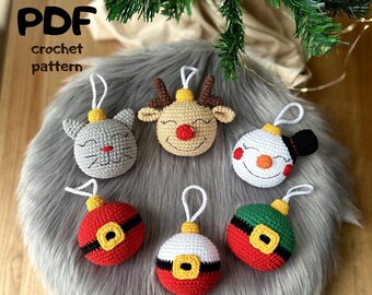 May include: Six crocheted Christmas ornaments with different designs. The ornaments are a reindeer, a snowman, a cat, and three different Santa Claus ornaments. The ornaments are on a gray fuzzy surface.