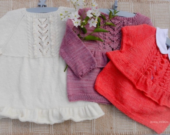 May include: Three knitted sweaters in white, pink, and red with intricate lace patterns. The sweaters have ruffled edges and are displayed on hangers.