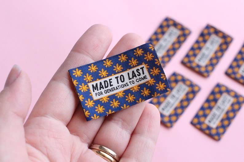 May include: A close-up of a blue fabric label with a yellow flower pattern. The label reads "Made to Last for Generations to Come".