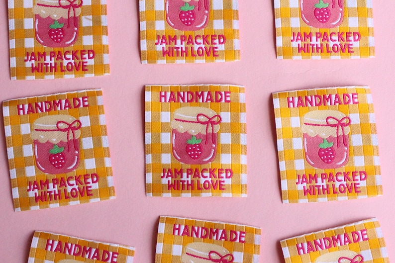 May include: Square fabric labels with a yellow and white checkered pattern. Each label features a pink jar of jam with a strawberry and the text "JAM PACKED WITH LOVE" and "HANDMADE" in pink.