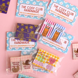 Peut inclure: Assortiment d'&eacute;tiquettes tiss&eacute;es color&eacute;es avec diff&eacute;rents motifs et textes. Les &eacute;tiquettes pr&eacute;sentent des phrases telles que "&Eacute;dition tr&egrave;s limit&eacute;e", "Unique", "Mode tr&egrave;s lente", "Ceci a &eacute;t&eacute; fait &agrave; la main sp&eacute;cialement pour vous" et "Aliment&eacute; par d'innombrables tasses de th&eacute;".