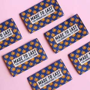 May include: Six blue fabric labels with a yellow floral pattern and the text "MADE TO LAST FOR GENERATIONS TO COME" printed in black.