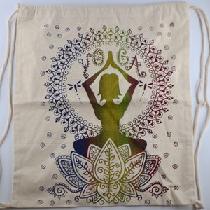 May include: A white drawstring bag with a colorful mandala design featuring a yoga pose and the word "YOGA" in the center. The mandala is surrounded by a circle of smaller dots.
