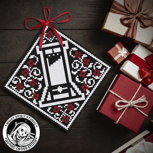 May include: A black and white cross stitch pattern of a guillotine with red flowers around it. The pattern is on a black background and is framed with a red ribbon. The pattern is labeled "Night Spirit Studio Gothic Cross Stitch".