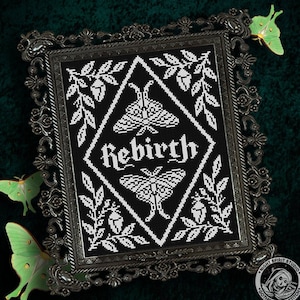 May include: Black and white cross stitch pattern featuring the word "Rebirth" in a gothic font. The design includes two moths, leaves, and other botanical elements.