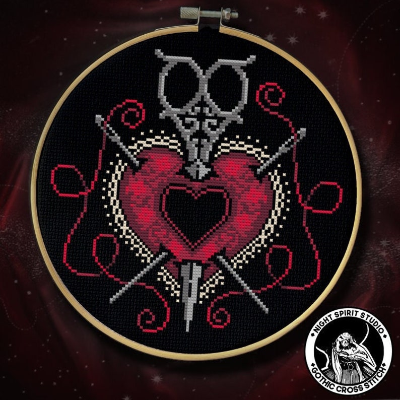 Puede incluir: Un dise&ntilde;o de bordado de punto de cruz negro y rojo con un coraz&oacute;n atravesado por dos agujas y un par de tijeras. El dise&ntilde;o est&aacute; rodeado de bucles de hilo rojo y un fondo blanco. El bordado est&aacute; enmarcado en un aro de madera. La imagen tambi&eacute;n incluye un logotipo para "Night Spirit Studio Gothic Cross Stitch".