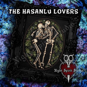 May include: A framed cross-stitch artwork titled "The Hasanlu Lovers" depicting two skeletons in an embrace. The design is set against a dark background with green foliage. The text "Night Spirit Studio" is visible.